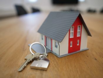large key lying on table next to tiny house